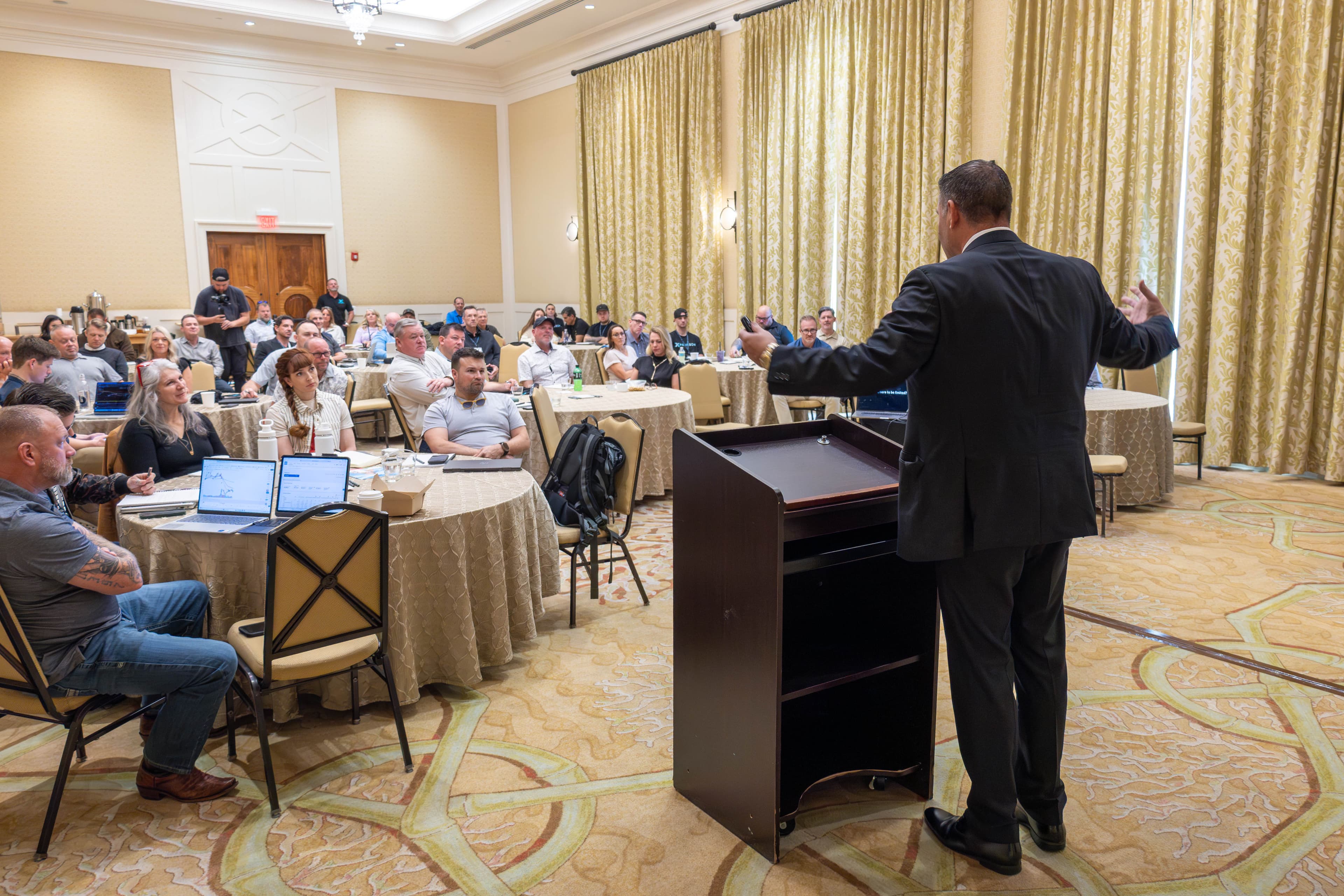 Professional speaker presenting to attendees in premium venue