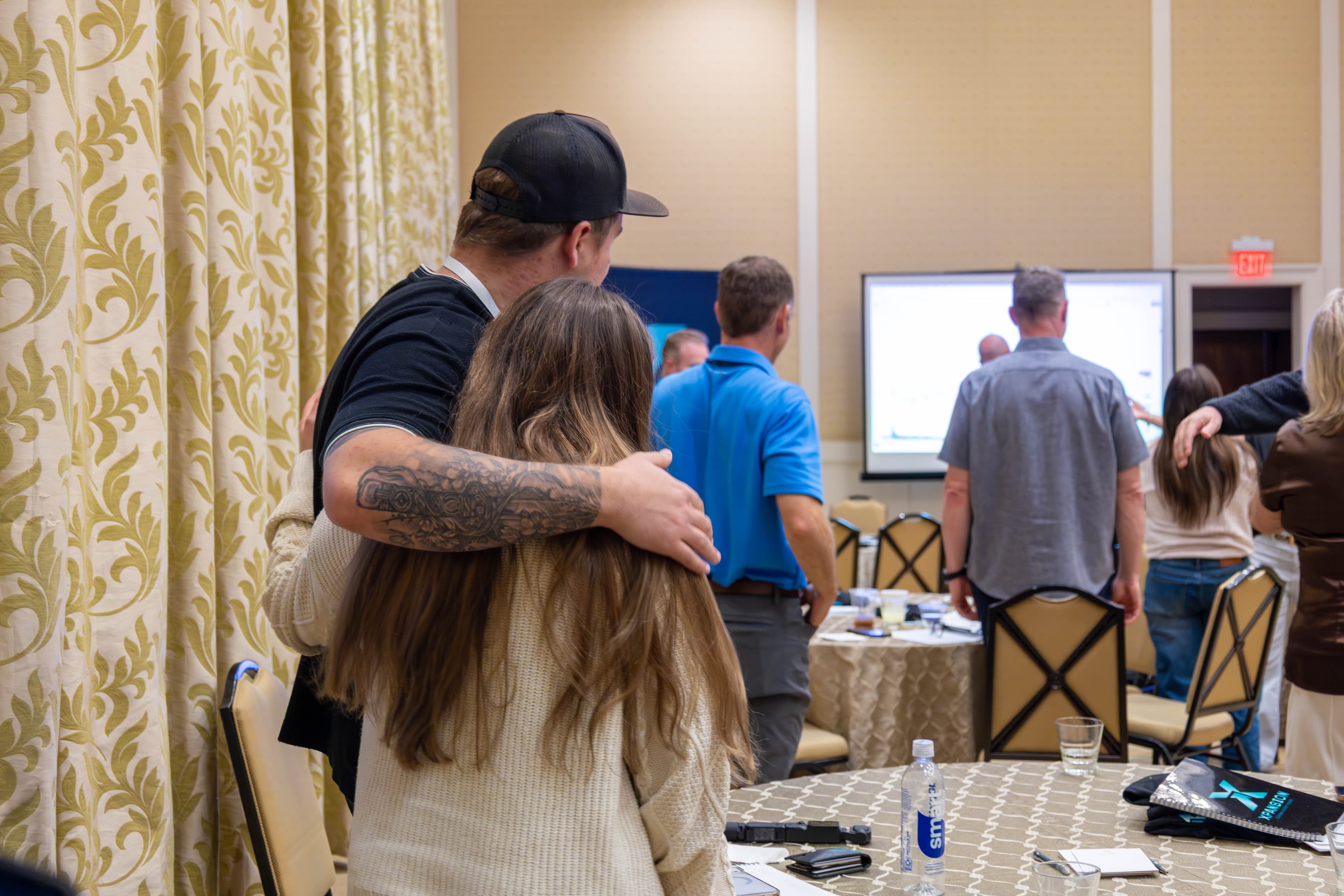 Couple embracing while watching presentation