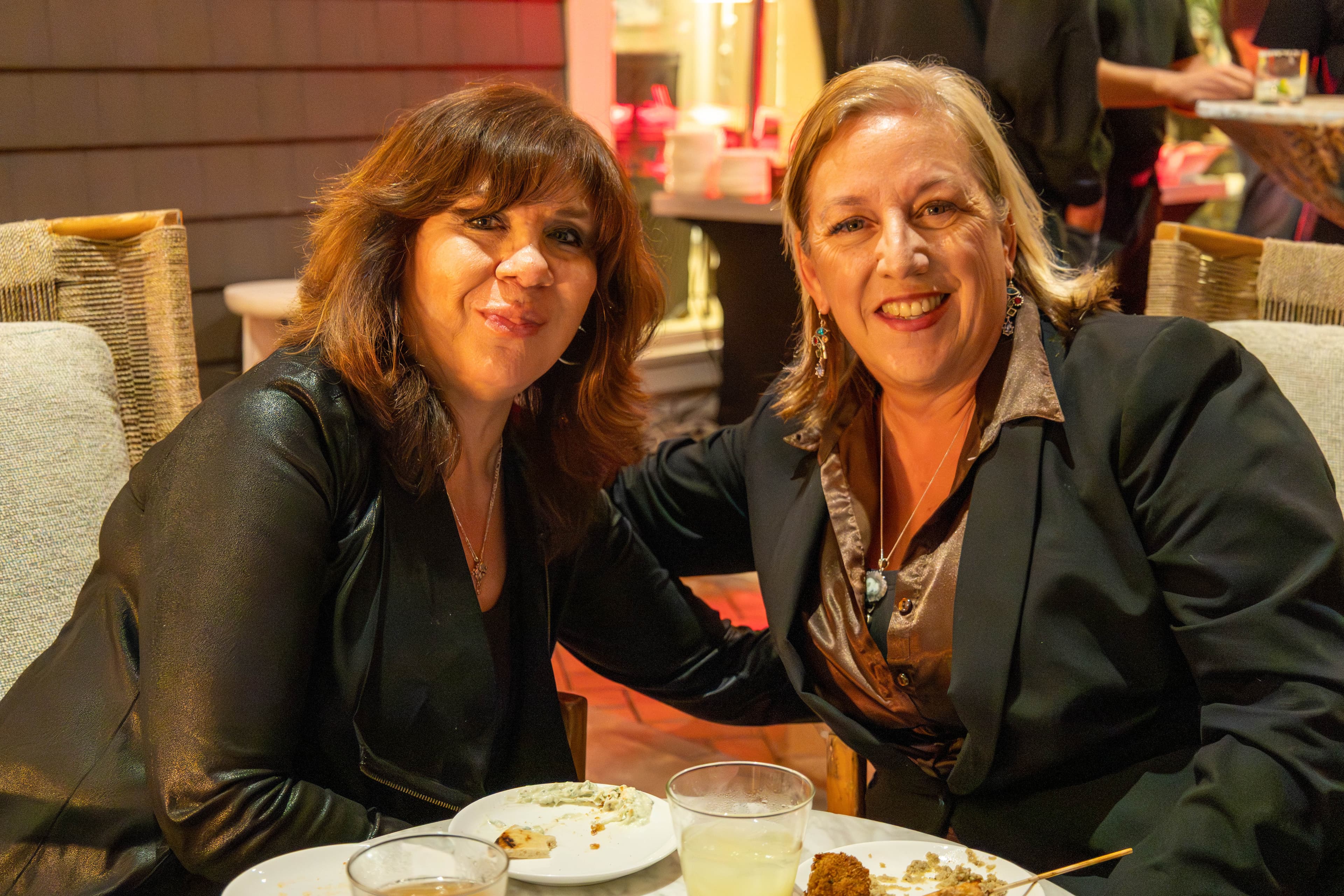 Two women smiling at dinner event